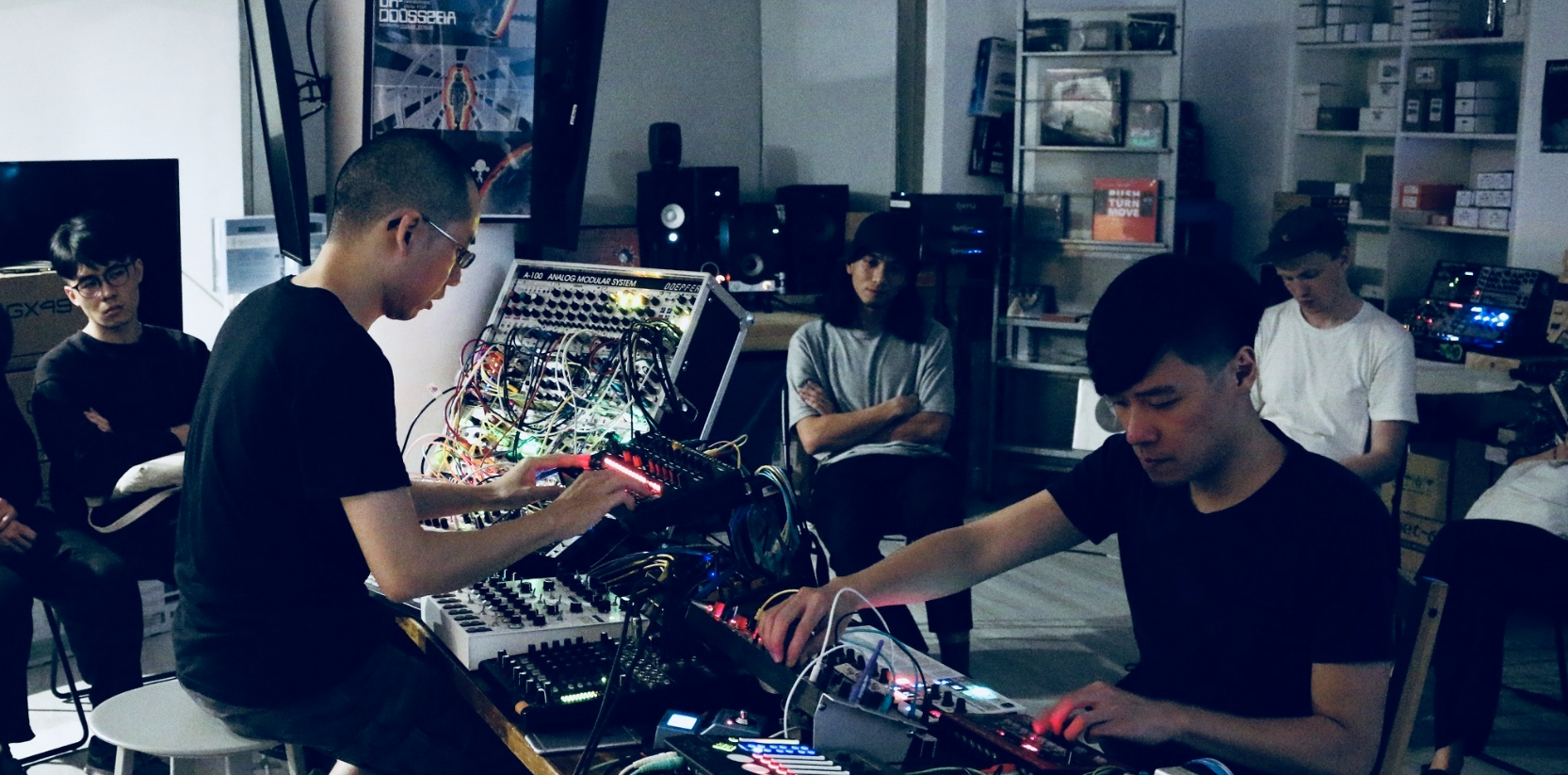 A room full of boys twiddling with synths. 